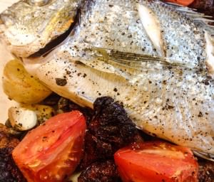 Baked sea bass with sun dried tomatoes, capers and potatoes