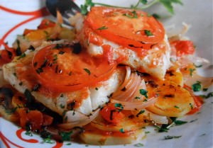 Oven-baked cod steaks with potatoes, tomatoes and onions