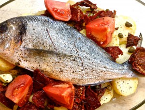 Baked sea bass with sun dried tomatoes, capers and potatoes