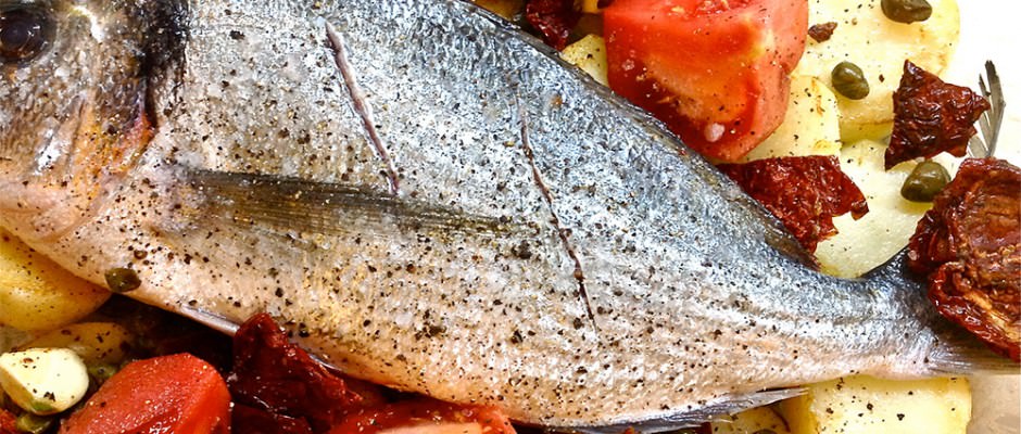 Baked sea bass with sun dried tomatoes, capers and potatoes